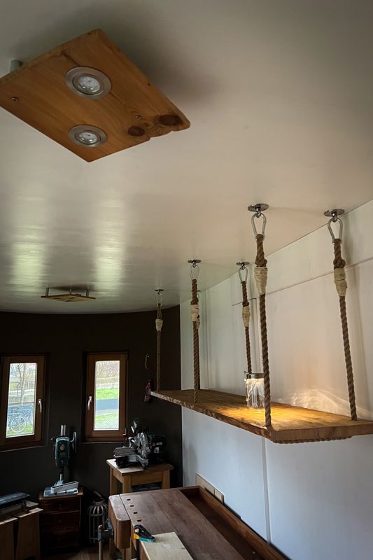 Werkstatt eingerichtet mit einem Hängeregal und Deckenlampen
